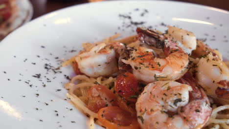 pomodoro de camarones en un plato espolvoreado con perejil, pasta de gambas al ajillo cubierta con camarones, deslizador de cerca 4k
