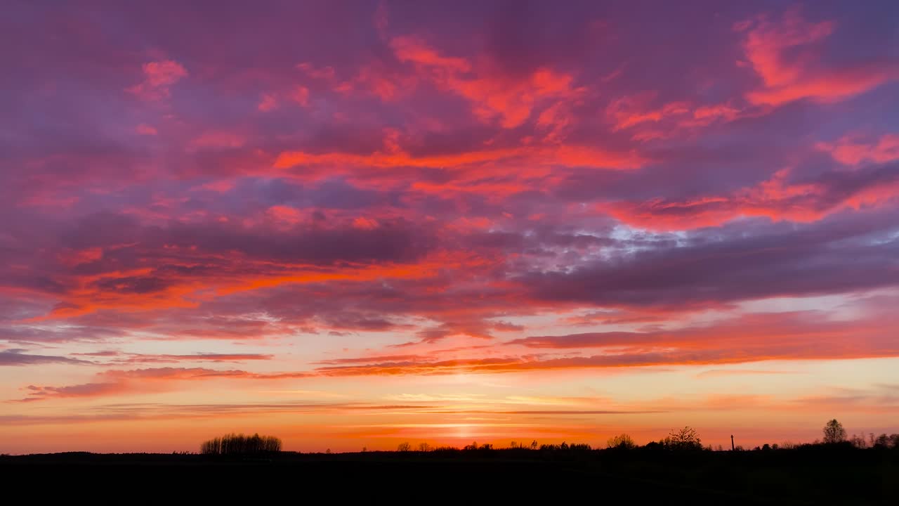 dramático cielo de nubes púrpura durante la hora dorada de la puesta de sol, campo letón
