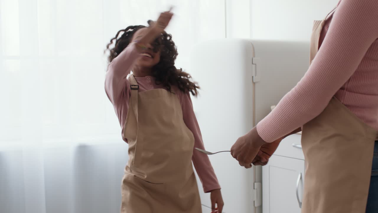 Mother and Daughter Dancing in the Kitchen