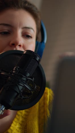 vertical video: woman checking sound before recording podcast in home studio