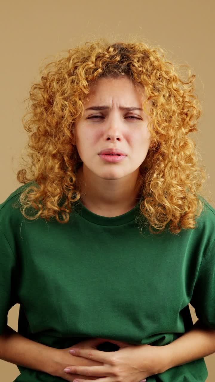 Giovane donna che prova dolore o disagio allo stomaco