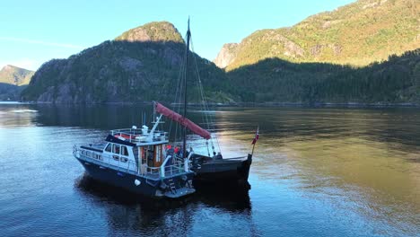 viking ship and motorboat sailing in a norwegian fjord