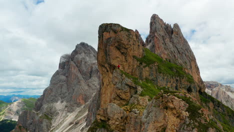 man in distance runs to cliff of seceda peak italy dolomites