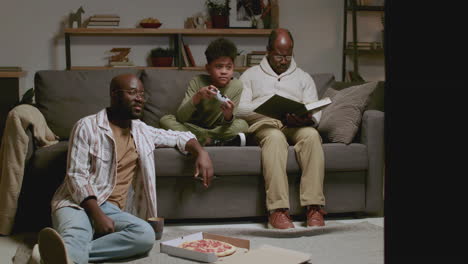 black men and boy in the living room at night