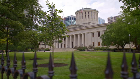 Ohio-State-Capitol-building-in-Columbus,-Ohio-with-video-looking-through-fence-and-moving-up