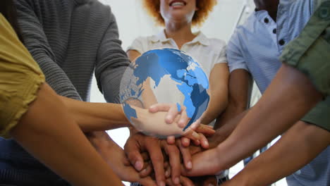 animation of globe over diverse business people stacking hands