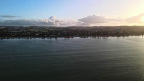 cloudy sunset over orewa beach in new zealand