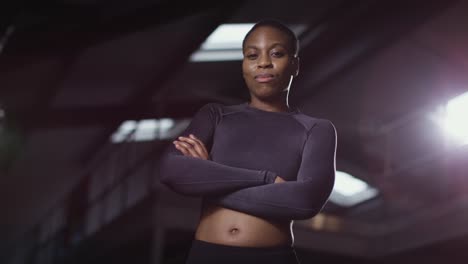 studio portrait of smiling woman wearing fitness clothing standing in gym 1