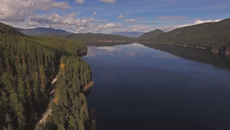 Toma-Aérea-De-Drones-En-Montana-En-Un-Lago-Con-Un-Bote-En-Otoño-O-En-Otoño