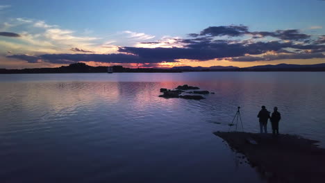 drone shooting through two photographers, shooting at a dam