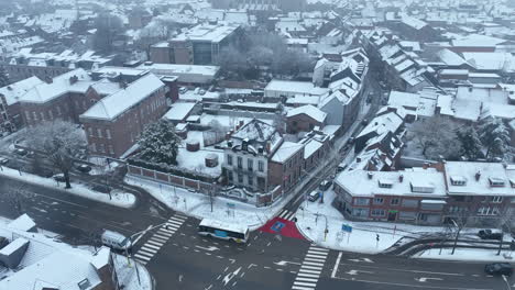 Winter-drone-flight-over-white-snow-covered-city-of-Tongeren,-Belgium