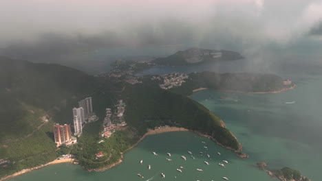 dron aéreo tiro lento de la playa de la bahía sur, hong kong con nubes bajas y yates de amarre