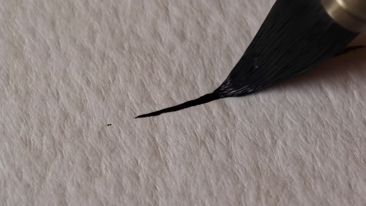 Paintbrush leaving a black mark on a textured white surface