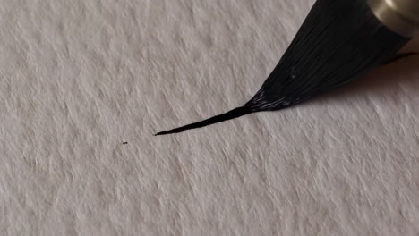 paintbrush leaving a black mark on a textured white surface