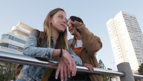 Low-angle-of-a-Caucasian-and-a-mixed-race-girl-whispering