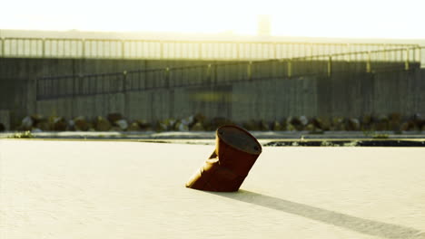rusty barrel abandoned on sandy shore during golden hour