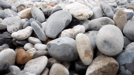 round pebble beach grey texture stones closeup shallow focus dolly right