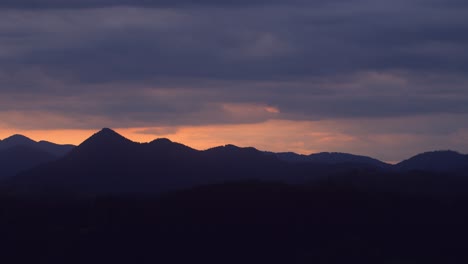 beautiful golden hour colors behind mountain range, time lapse of cloud movement