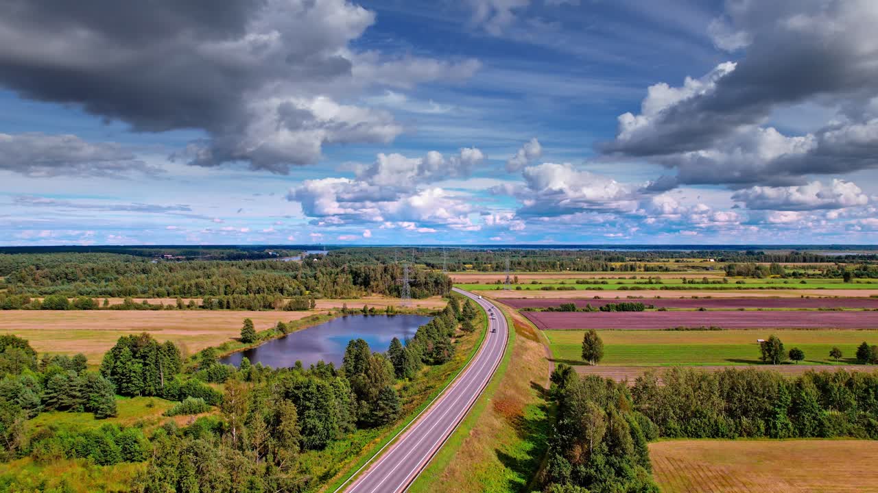 Scenic aerial view of rural Latvia featuring fields and a winding road