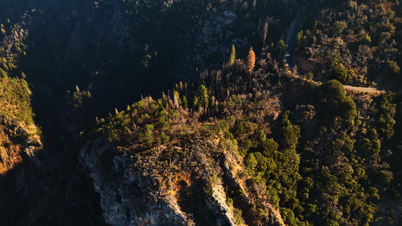 High rocks and cliffs of the mountainous area in California. Drone footage above the mountains on sunny day.