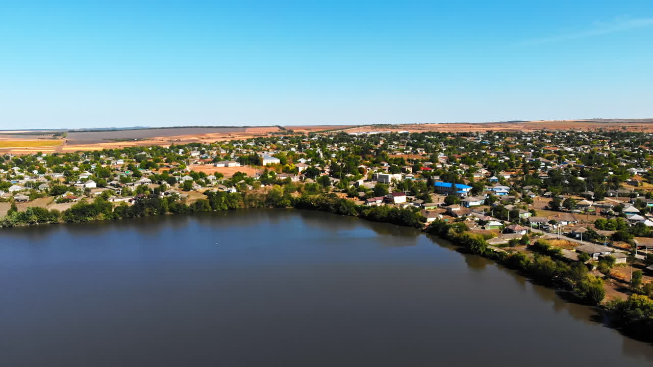 Maramonovca village located on the coast of a lake. Aerial drone view with fields on the background in Moldova. Panoramic shot