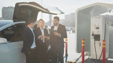 hombres de negocios discutiendo en la estación de carga de ev