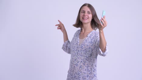 feliz joven hermosa mujer embarazada con teléfono