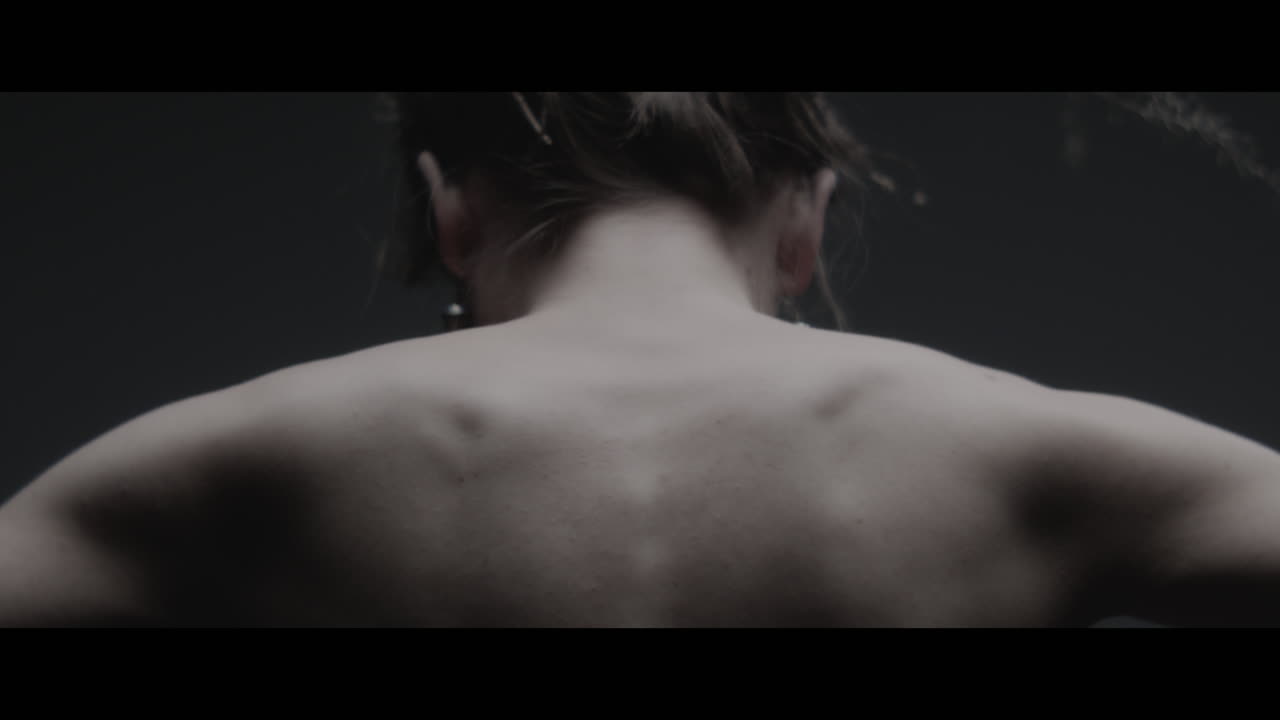 A woman dressed as mother nature moves slowly in a dance-like motion