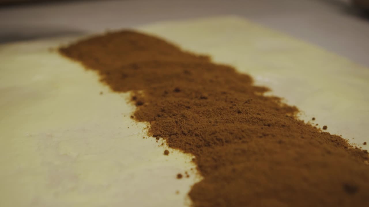 생 반죽에 계피 가루를 넣는 베이커