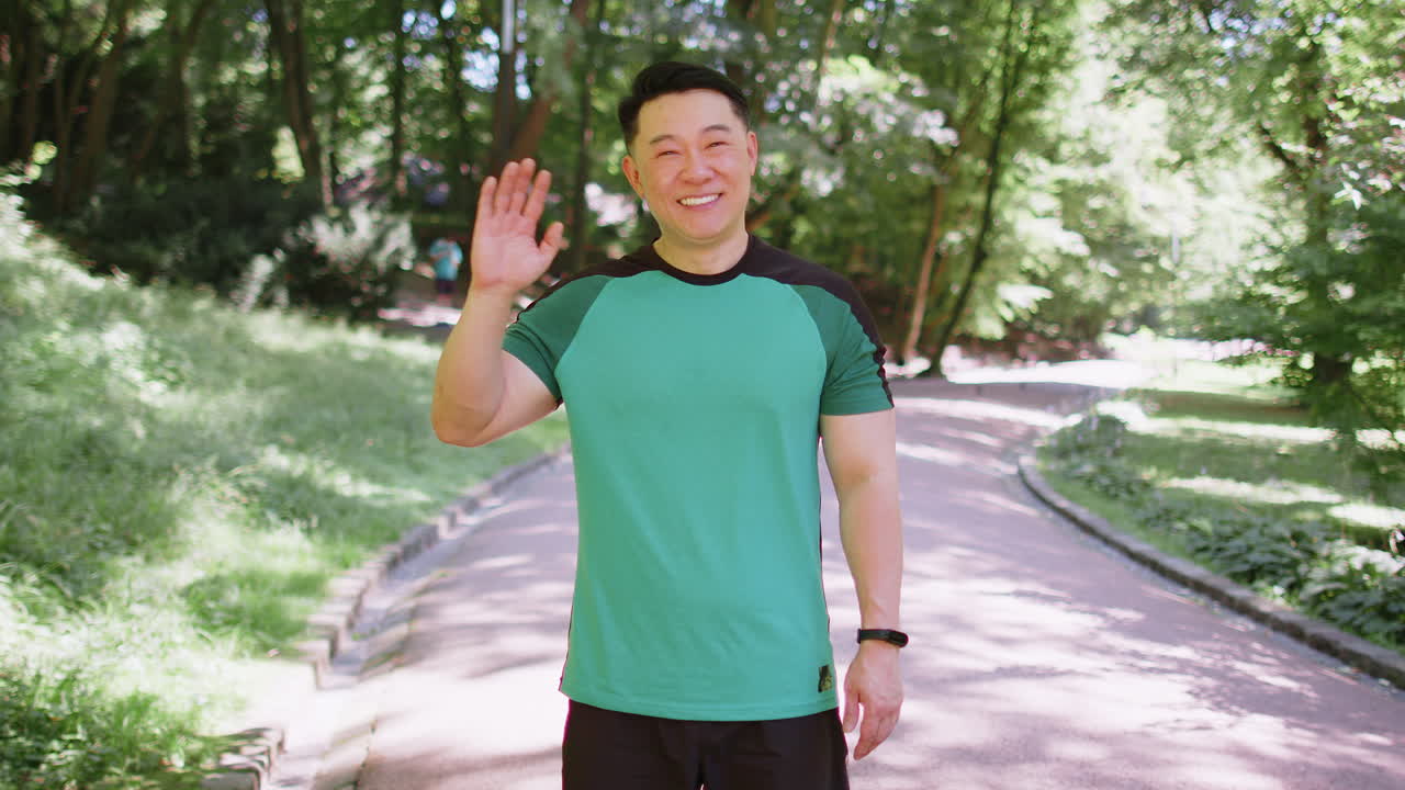 Athletic runner sport man waving hi hello welcome with hand greeting with hospitable friendly smile