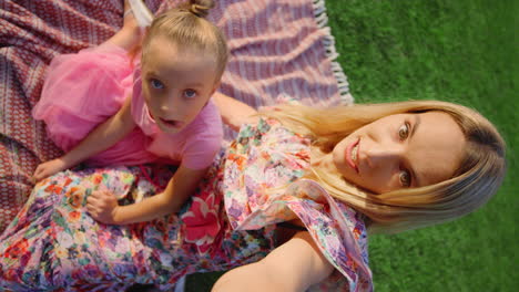 beautiful mother and cute daughter having fun in park at sunny day.