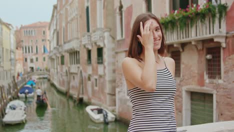 happy female traveler on bridge over canal