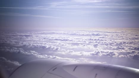 plane flying above huge white clouds window view