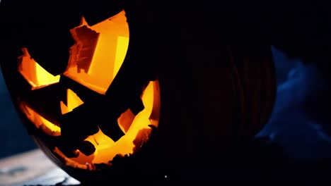 close-up of a lit jack-o-lantern with smoke