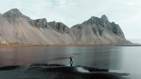 Antena-De-Turista-Explorando-La-Playa-Turística-De-Arena-Negra-De-Stokksnes,-Islandia