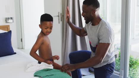 Afroamerikanischer-Vater-Hilft-Seinem-Sohn-Beim-Anziehen-Im-Schlafzimmer