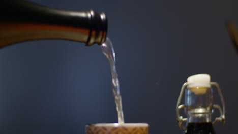 cook pouring sake in small cup serving on table