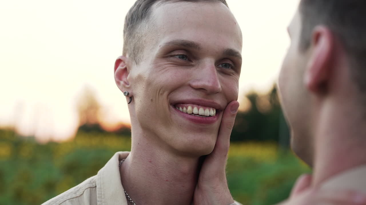 двое мужчин разговаривают и целуются.