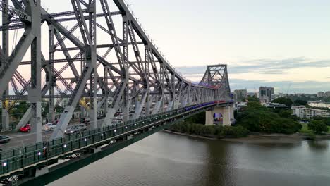 Zoomed-drone-footage-rising-from-the-road-to-the-top-of-the-Story-Bridge-in-Brisbane,-Queensland-in-Australia-with-Kangaroo-Point-in-the-background.