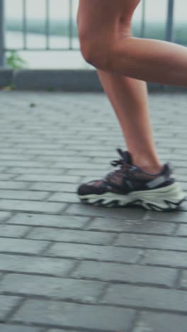 dynamic motion capture of running feet in athletic shoes on paved pathway with natural background showcasing speed and energy during exercise