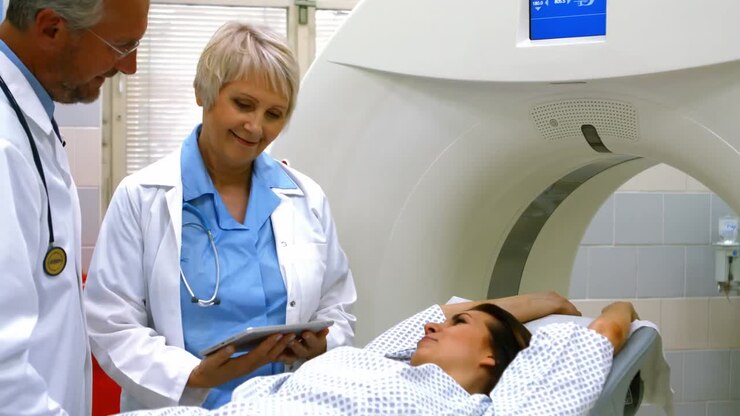Medici che spiegano la diagnosi a una paziente su un tablet digitale prima della risonanza magnetica