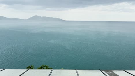 a storm approaches over the sea, viewed from a restaurant in phuket, thailand. the atmosphere is moody and dramatic