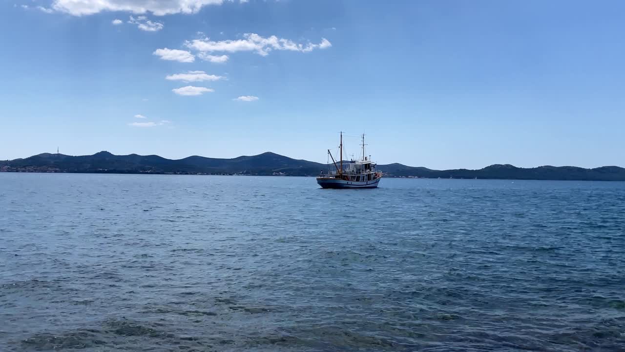 Time-lapse of a ship moored in the Adriatic Sea on a sunny day near Zadar Croatia with waves passing.