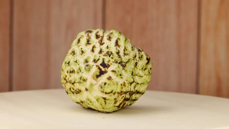 custard apple rotates on a wooden surface