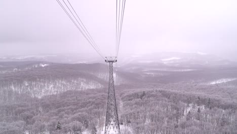 Vista-En-Cámara-Lenta-Desde-El-Frente-Del-Teleférico,-Cabalgando-Por-Encima-De-La-Nieve-En-El-Bosque-En-El-área-Natural