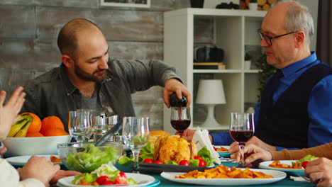 Young-man-serving-his-father-in-law-with-red-wine