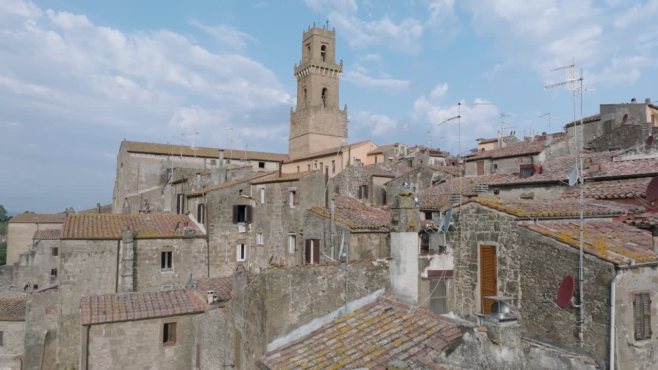 Aerial Drone view of the hilltop Medieval town of Pitigliano, Tuscany in morning light, flying low over red tile roofs and old buildings, in 4K