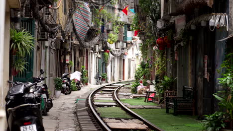 train tracks running through a narrow alley in hanoi, vietnam
