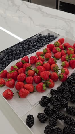 a variety of fresh berries arranged for cake and muffin decorations at a bakery shop
