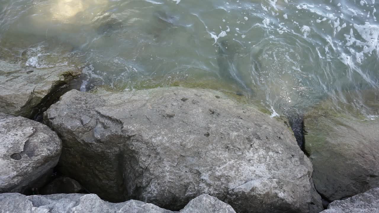 Movimento rallentato di onde che colpiscono le rocce sulla riva.